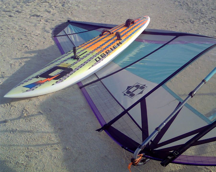 Mike Kimbro's Aerotech 7.5 sail behind his vintage 1989 O'Brien Epoxy Lite 9.9 windsurfer.